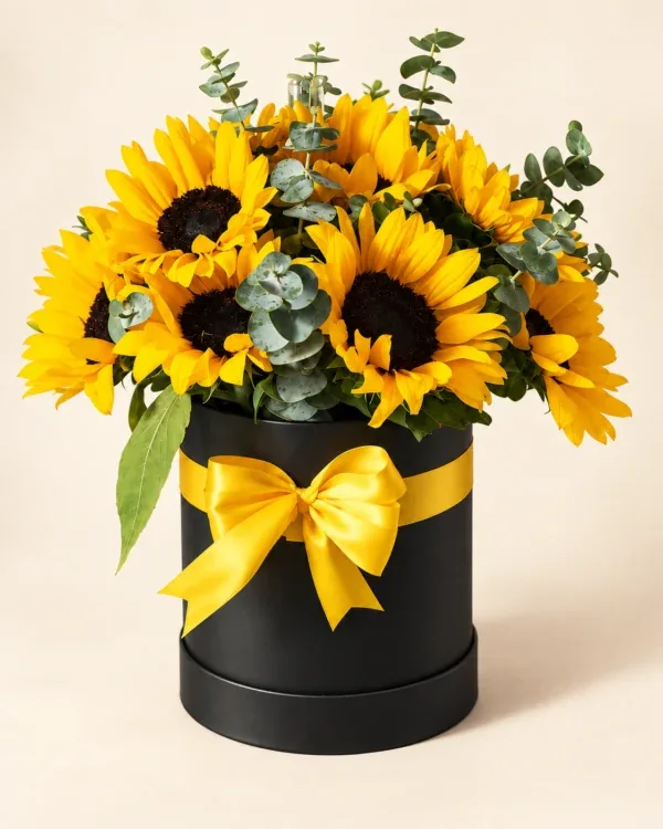Arreglo de girasoles con follaje en caja negra y lazo amarillo