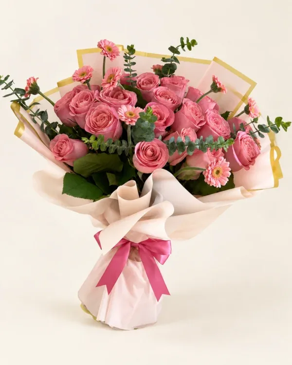 Ramo de 24 rosas rosadas con eucalipto, envoltura clara y lazo rosado sobre fondo claro en Pereira