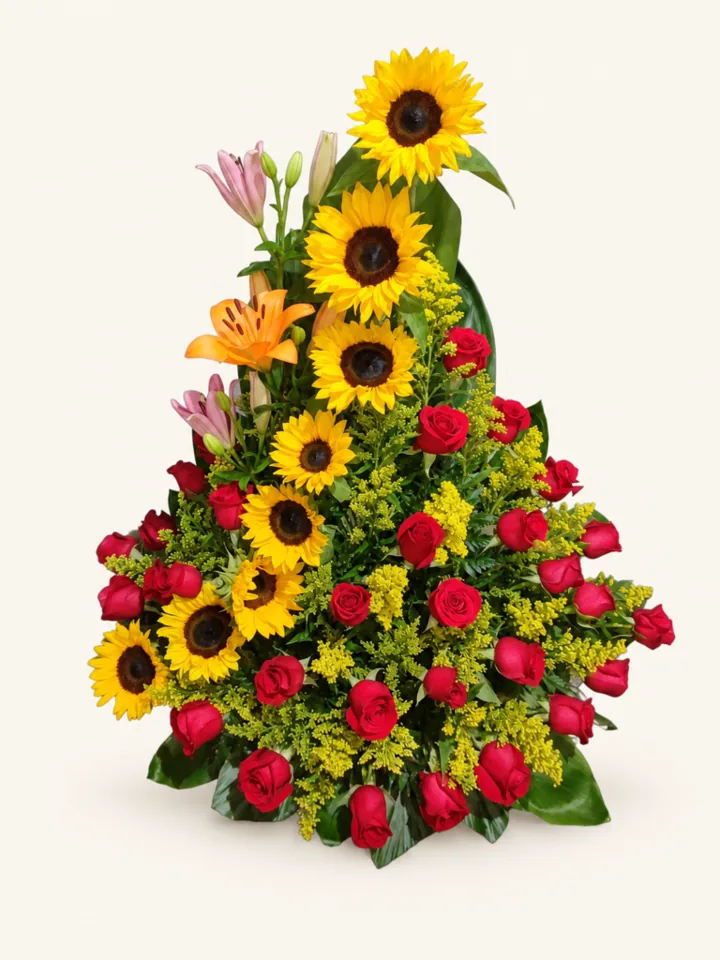 Arreglo de girasoles en cascada con rosas rojas, lirios y follaje. Sobre fondo crema. en Pereira