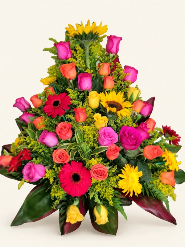 Arreglo de rosas fucsias, salmón y amarillas con gerberas, girasoles y follaje. Sobre fondo crema. en Pereira