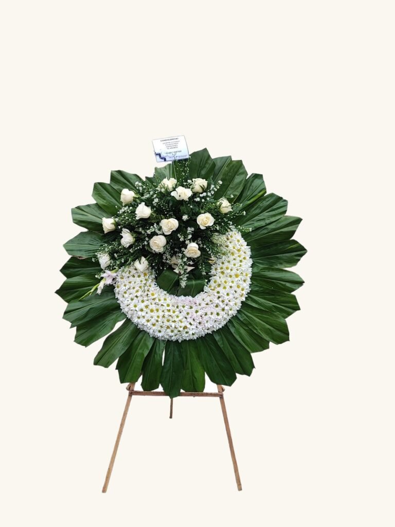 Corona fúnebre de flores blancas y follaje verde para condolencias en Pereira
